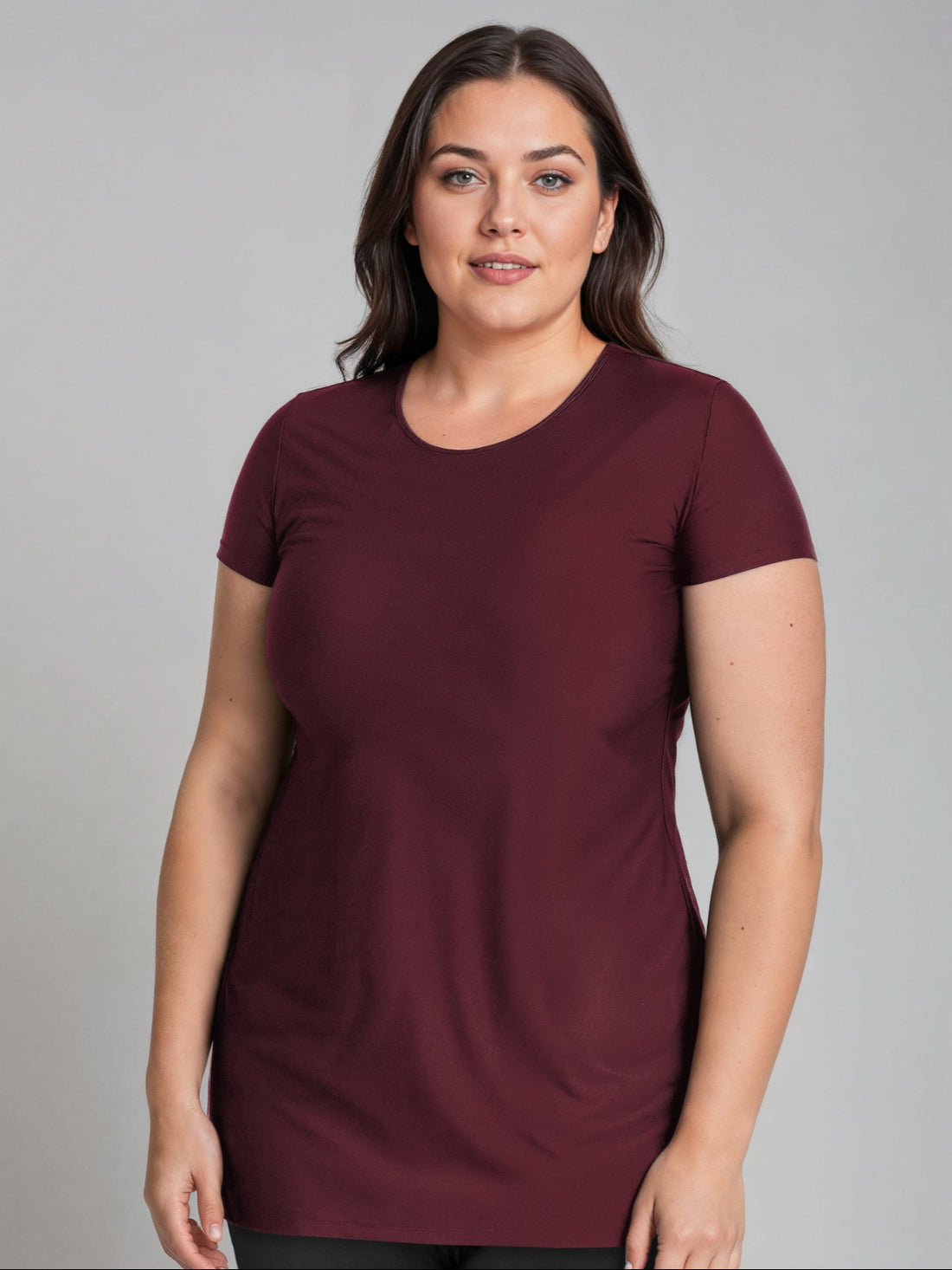 Woman wearing a maroon t-shirt against a gray background