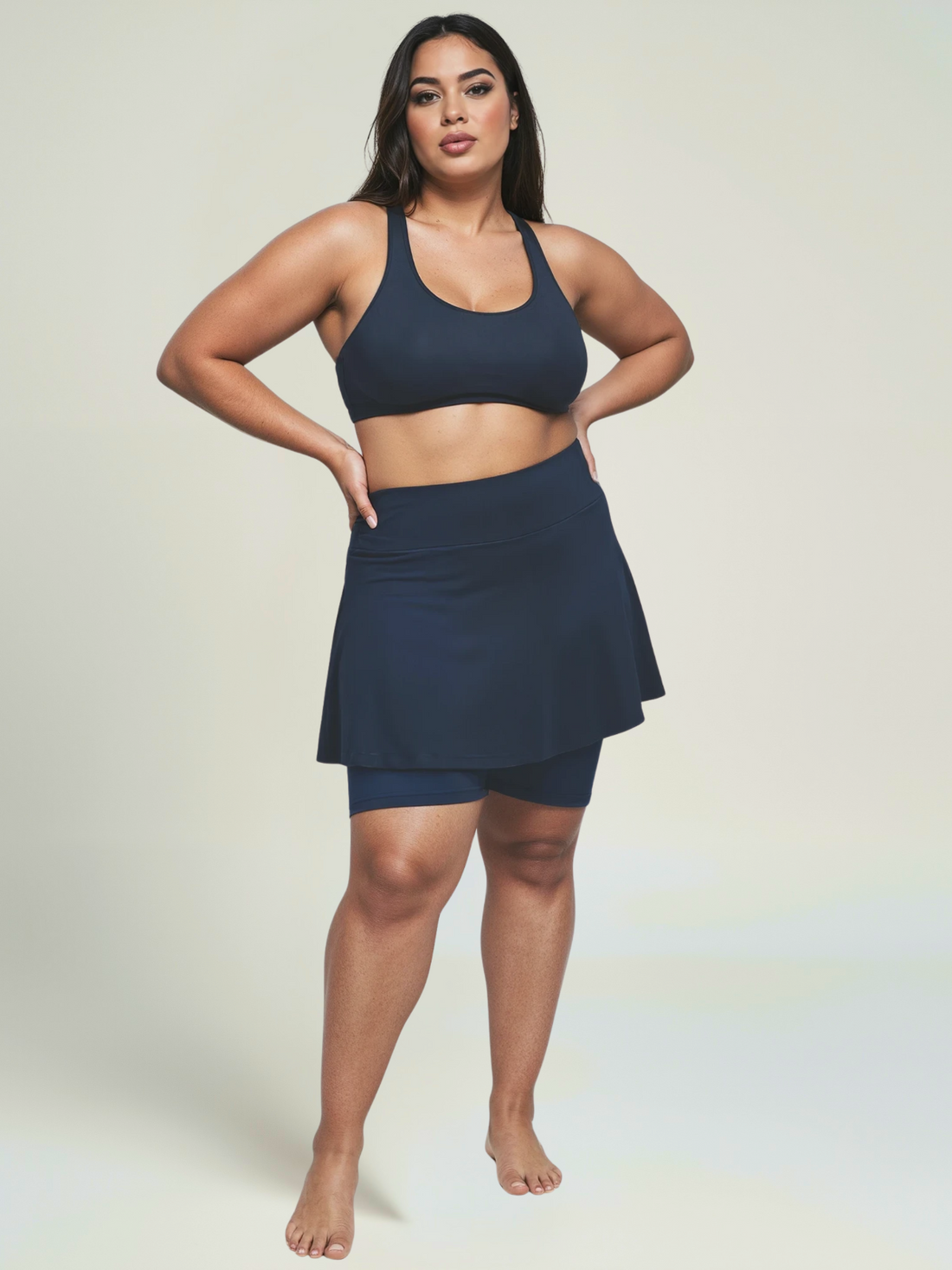 Woman wearing a navy blue athletic outfit on a plain background